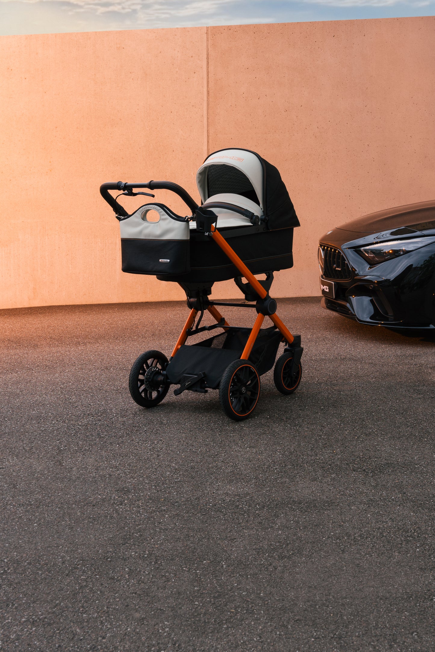 Kinderwagen mit Wanne auf einem Auto-Parkplatz