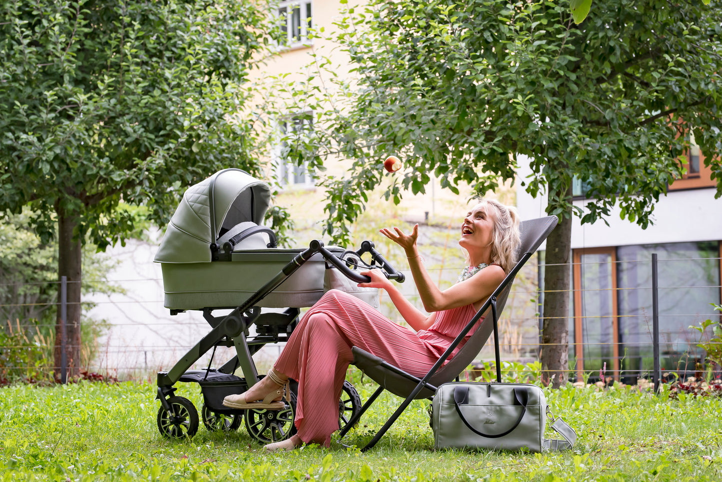 Frau im Garten mit einem Kinderwagen