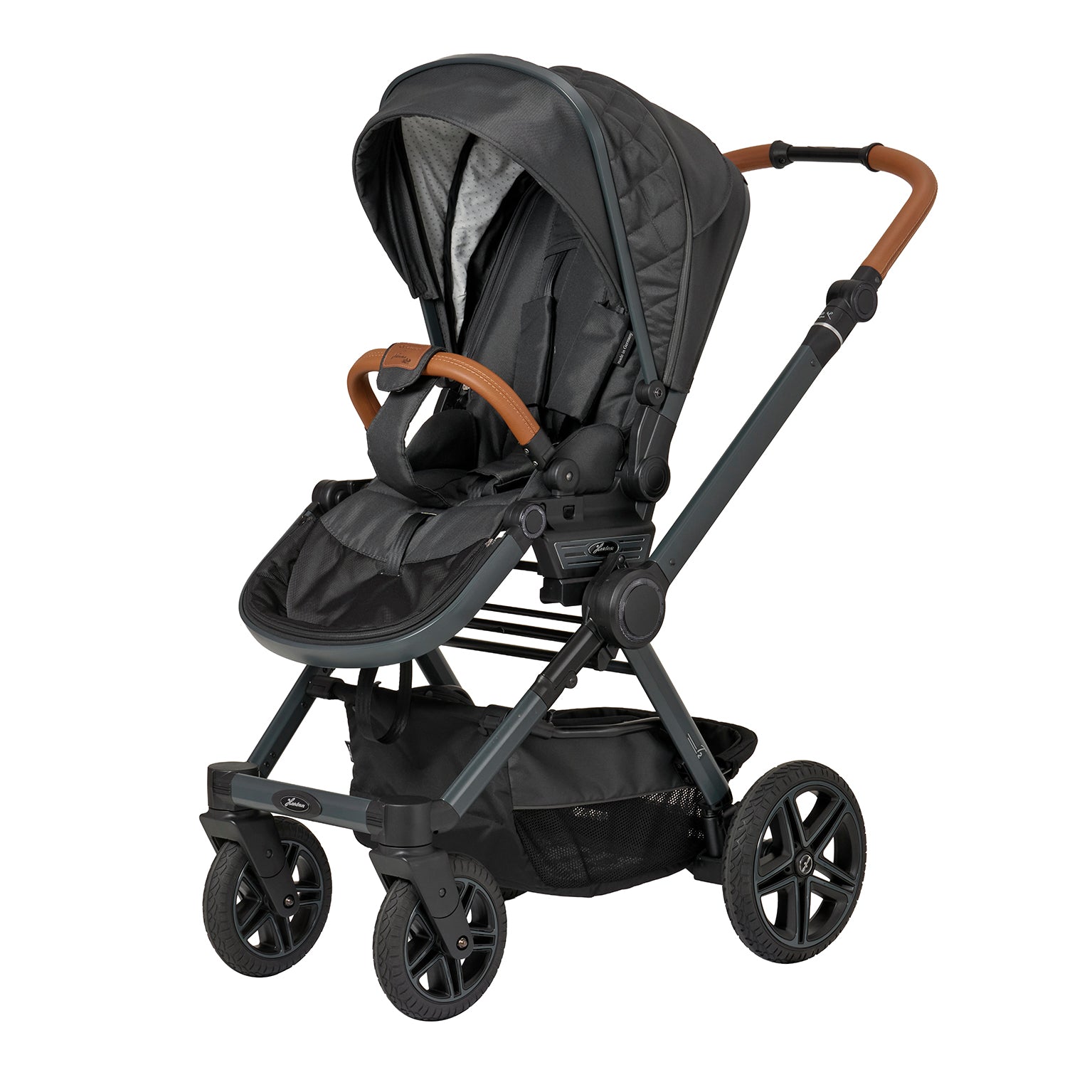 Kinderwagen in 605 / Walnut Grey mit verstellbarem Sportsitz und großem Sonnenverdeck.
Verdeck halb ausgeklappt 
Schutzbügel und Handgriff in braunen Leder.
Gestell in Anthrazitgrau.
Schräge Vorderansicht.