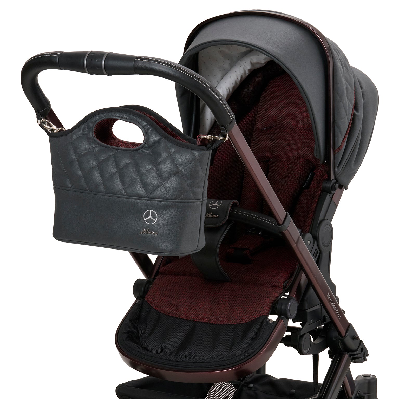 Bag2Go in 614 / Rubellit  mit mehreren Innenfächern und Schultergurt.
Der obere Teil der Tasche ist gesteppt.
Am Kinderwagengestell befestigt.
Schräge Vorderansicht.