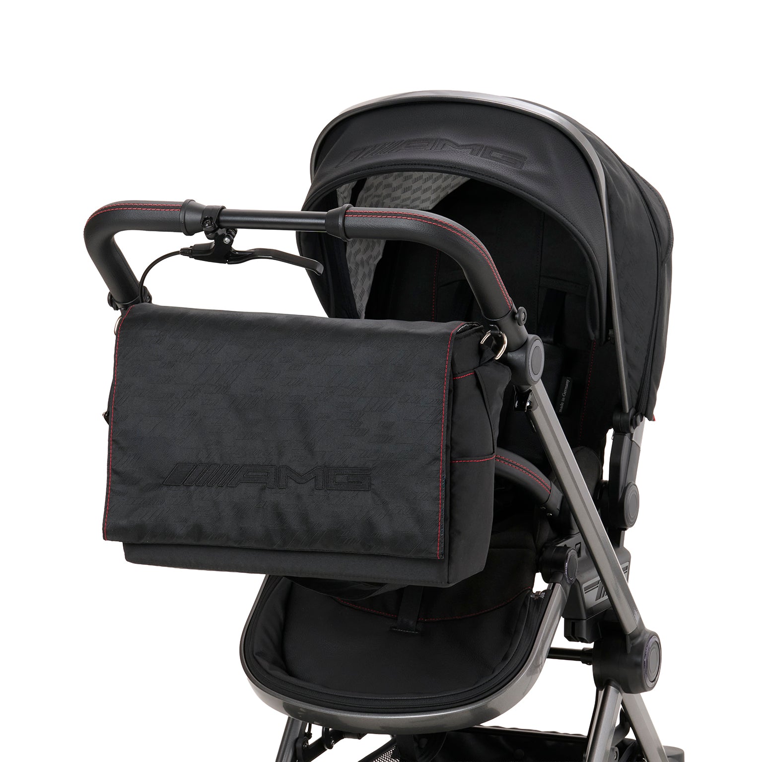 Wickeltasche in 620 / Nachtschwarz mit mehreren Innenfächern und Schultergurt.
Rote Ziernähte und AMG Stickerei.
Am Gestell befestigt.
Schräge Vorderansicht.