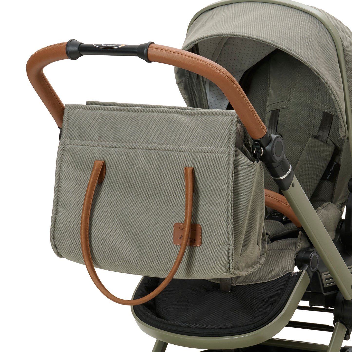 Wickeltasche Modern Style 608 / Pistachio mit mehreren Innenfächern und zusätzlichem Schultergurt.
Mit Vorrichtung am Sportwagen befestigt.
Schräge Vorderansicht.