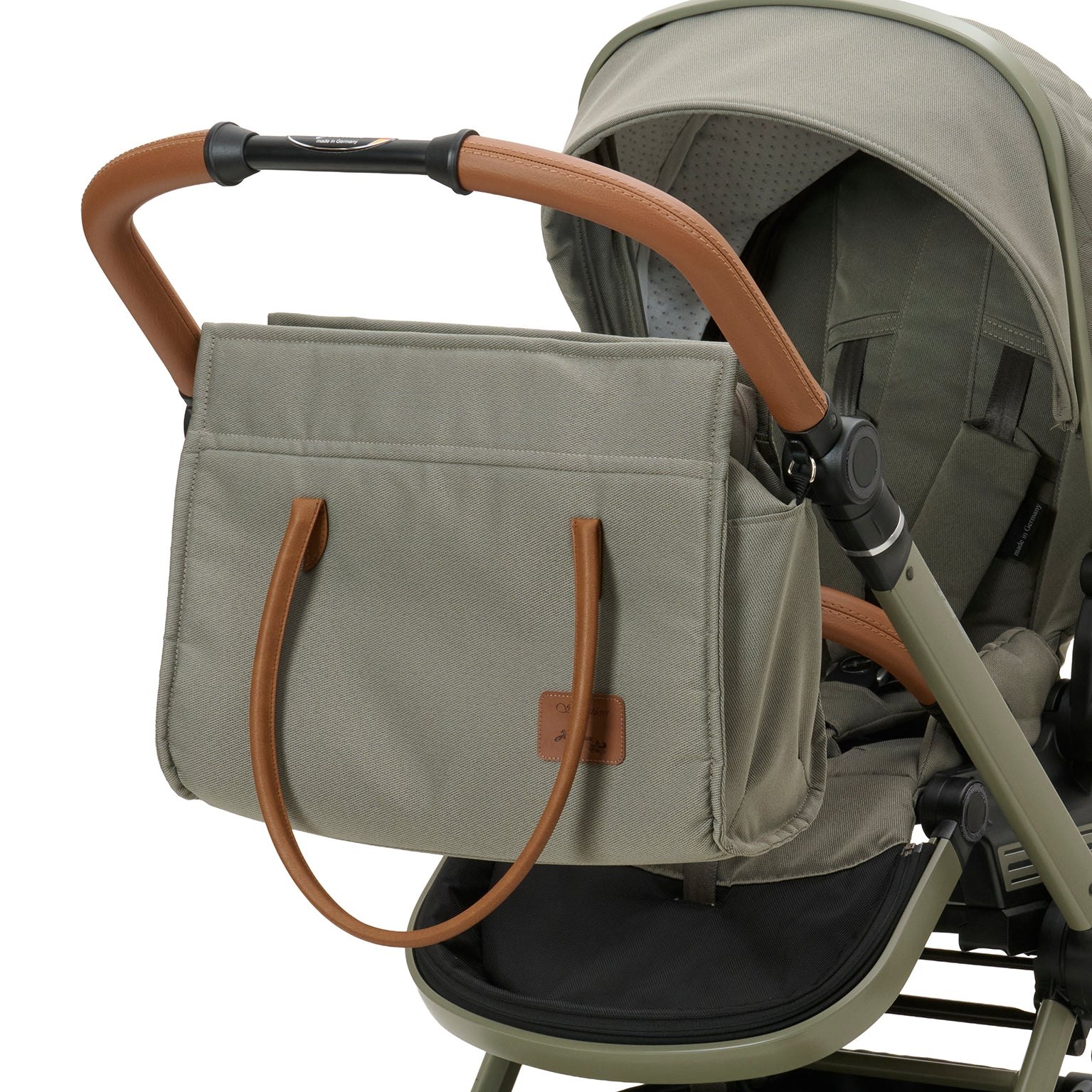 Wickeltasche Modern Style 608 / Pistachio mit mehreren Innenfächern und zusätzlichem Schultergurt.
Mit Vorrichtung am Sportwagen befestigt.
Schräge Vorderansicht.