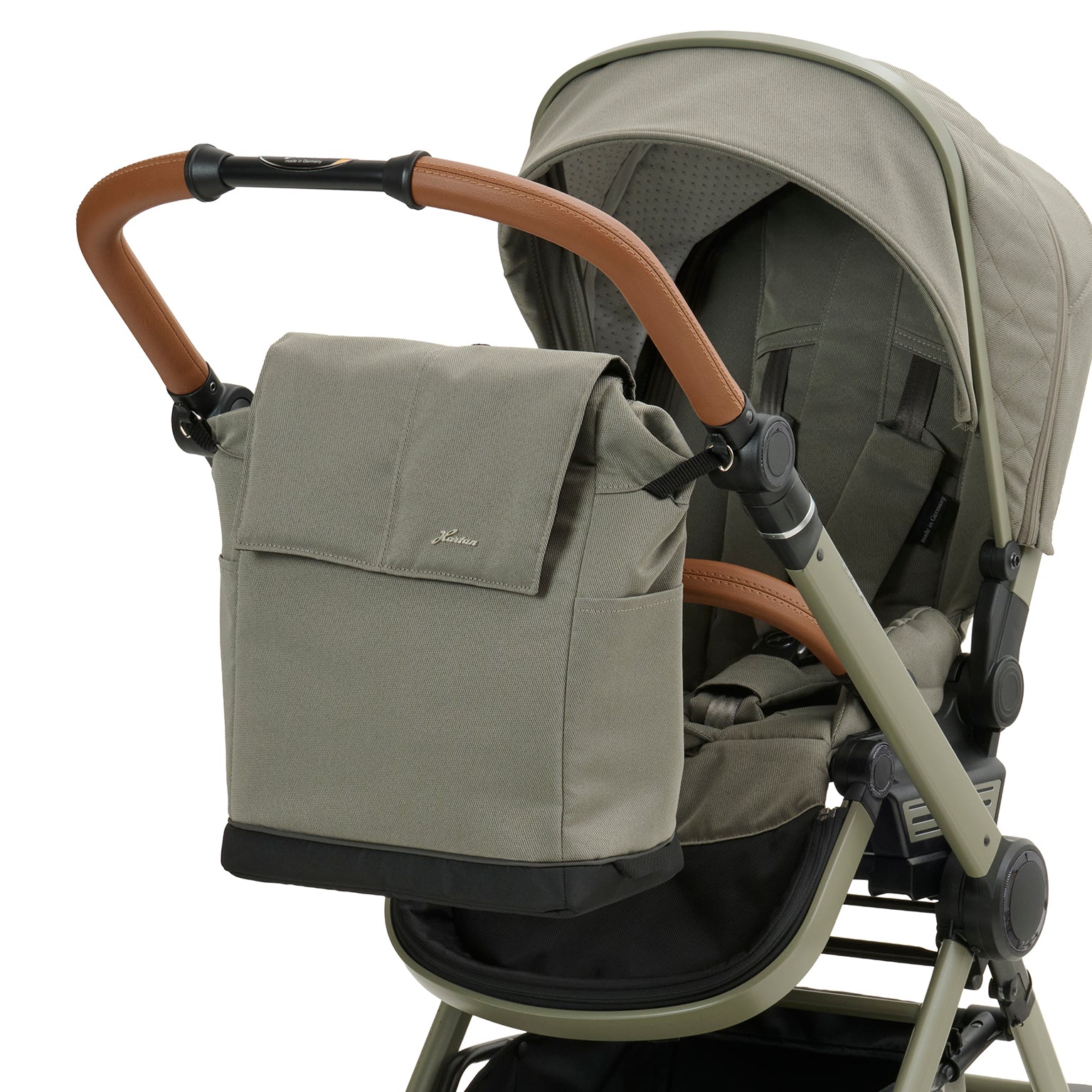 Wickeltasche Flexi Bag 608 / Pistachio  mit mehreren Innenfächern und Schultergurt.
Mit Vorrichtung am Sportwagen befestigt.
Schräge Vorderansicht.